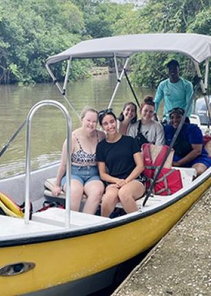 Celia Larson poses with her clinical group on a yellow boat