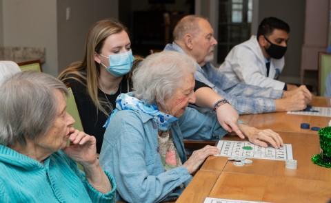 萨曼莎·摩根(D.O., ’25) plays bingo with a resident of The Cedars in Portland