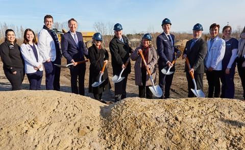 UNE leadership dig into the earth at the groundbreaking ceremony for the Harold and Bibby Center for Health Sciences on Tuesday, Nov. 29, 2022